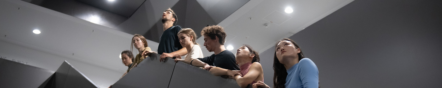 Sieben Personen auf einer Treppe in verschiedene Richtungen schauend