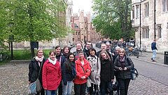 Personengruppe. Im Hintergrund Bäume und alte Gebäude